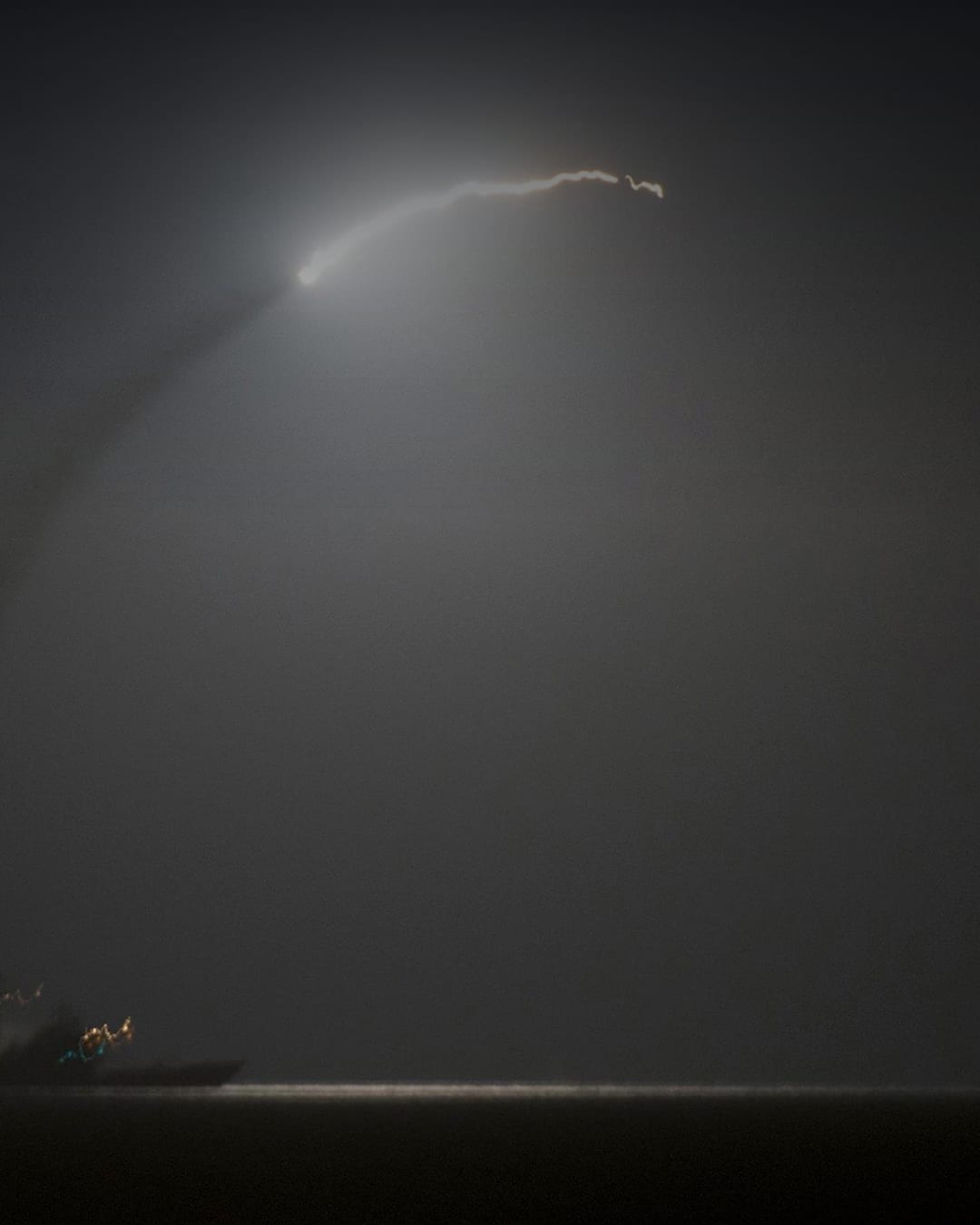 A U.S. Navy Tomahawk missile launches from a destroyer at night