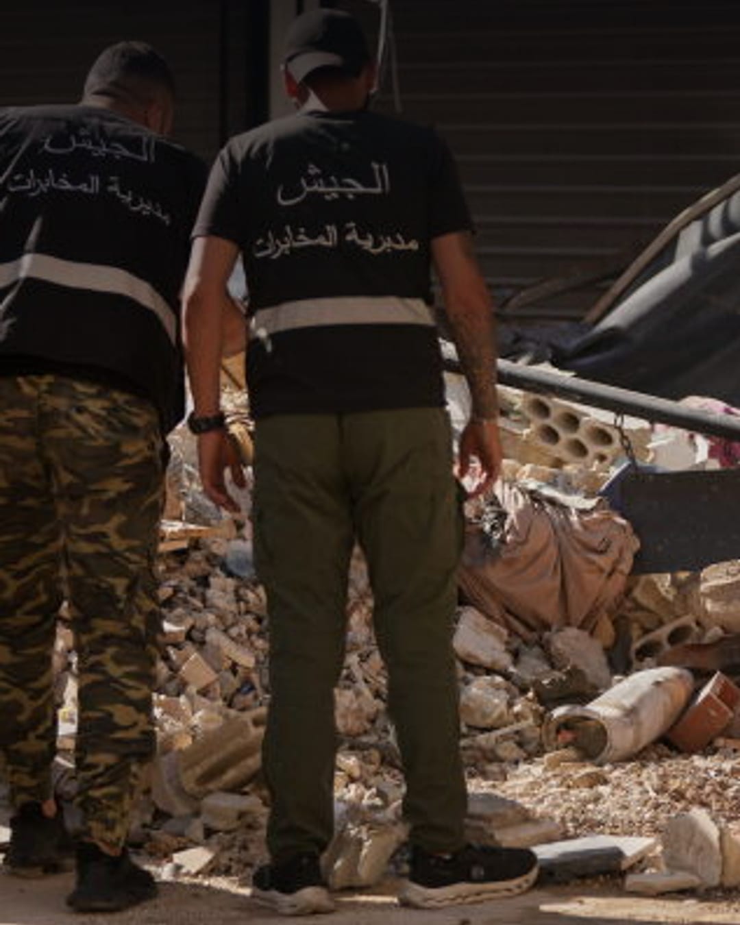 Lebanese intelligence officers inspect an unexploded missile in Beirut's southern suburb