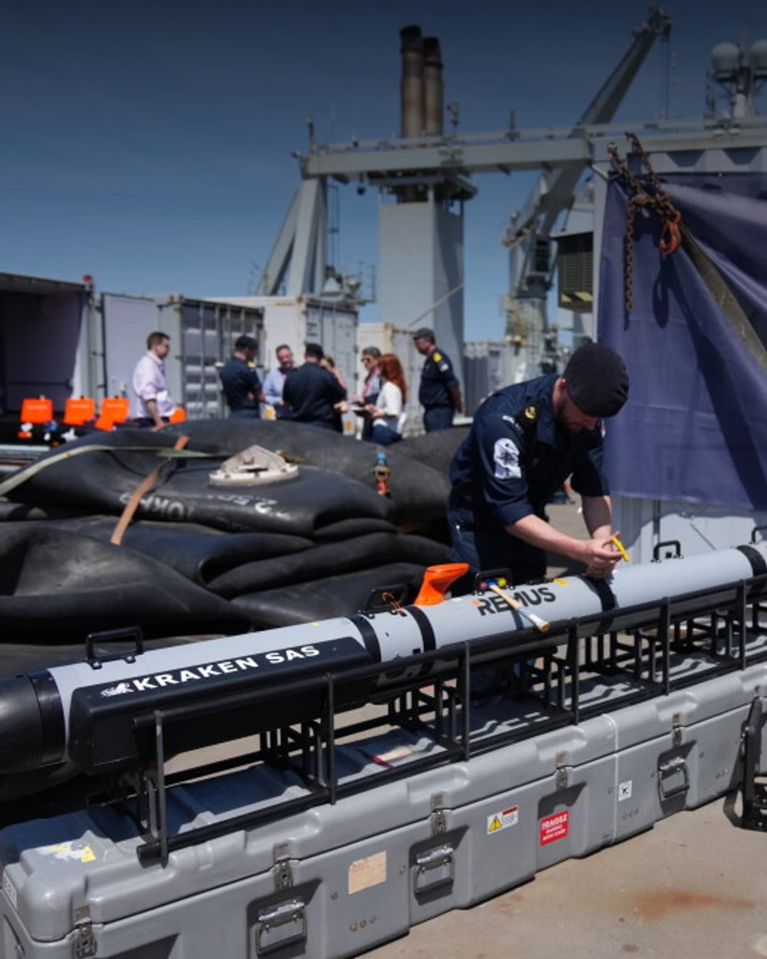 UK Royal Navy personnel inspect autonomous mine-hunting vehicles on RFA Lyme Bay