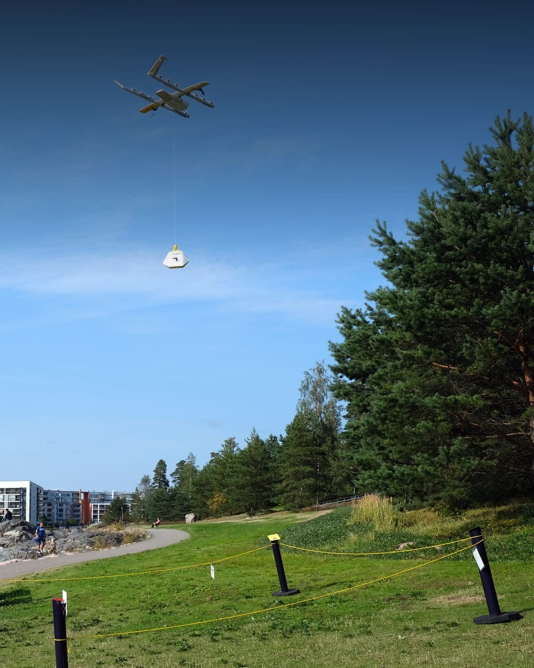 Wing delivery drone carrying a package over water in Helsinki