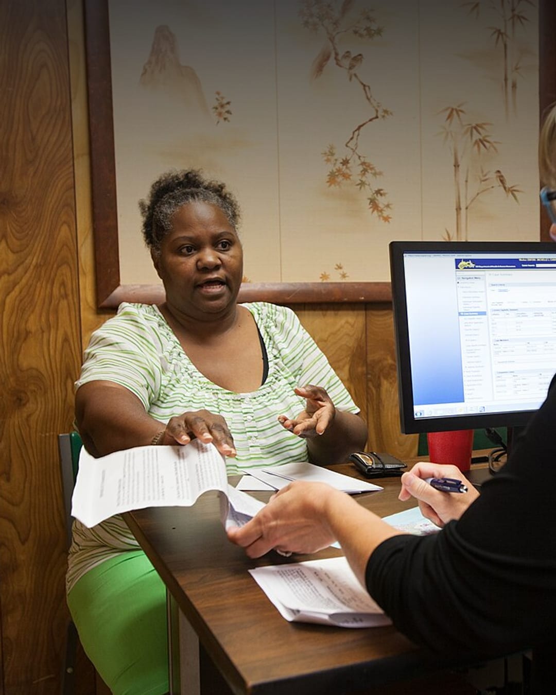 A USDA food assistance worker helps a woman with D-SNAP benefits